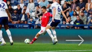 Ryan Hardie finalizando com a camisa vermelha do Wrexham em partida contra o Preston North End