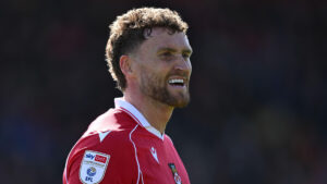 Dan Scarr sorrindo com a camisa do Wrexham