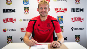 Joe Worrall assinando contrato com o Wrexham